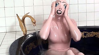Tanja takes a bath in her latex sex doll costume