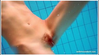 Gorgeous redhead’s hairy pussy glistens underwater